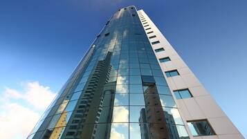 Un edificio alto y moderno con ventanas de vidrio reflectante y cielo despejado.