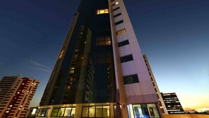 A high-rise building with multiple floors, large windows, and a modern architectural design. - HY Beach Flats (Recife)