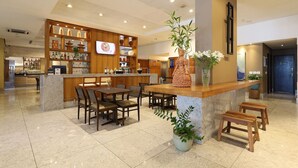 A modern hotel lobby with a bar area, seating arrangements, and a reception desk. - HY Beach Flats (Recife)