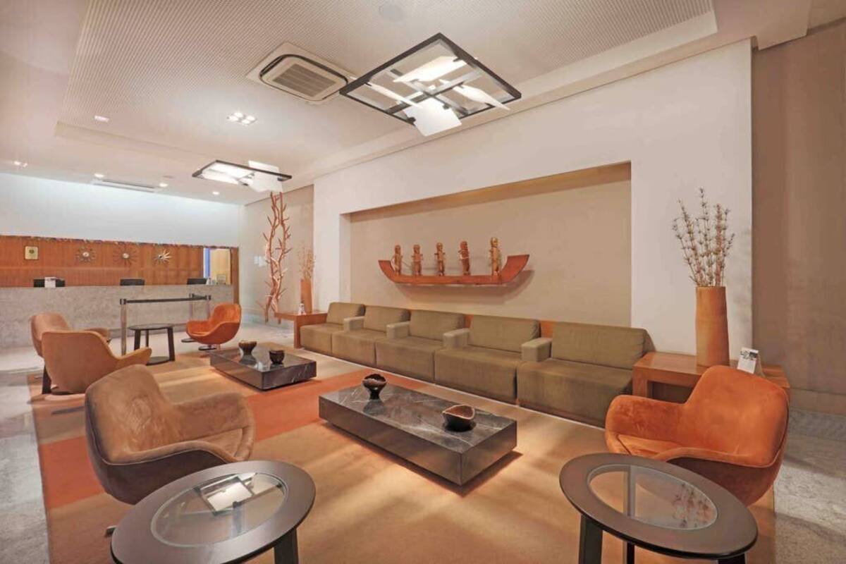 A modern living room with a sofa set, two armchairs, a coffee table, and a decorative wall piece.
