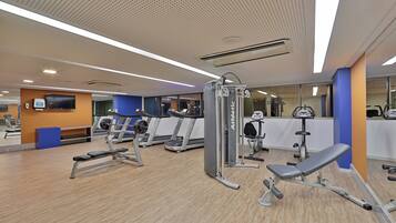A gym with treadmills, weight machines, and benches.