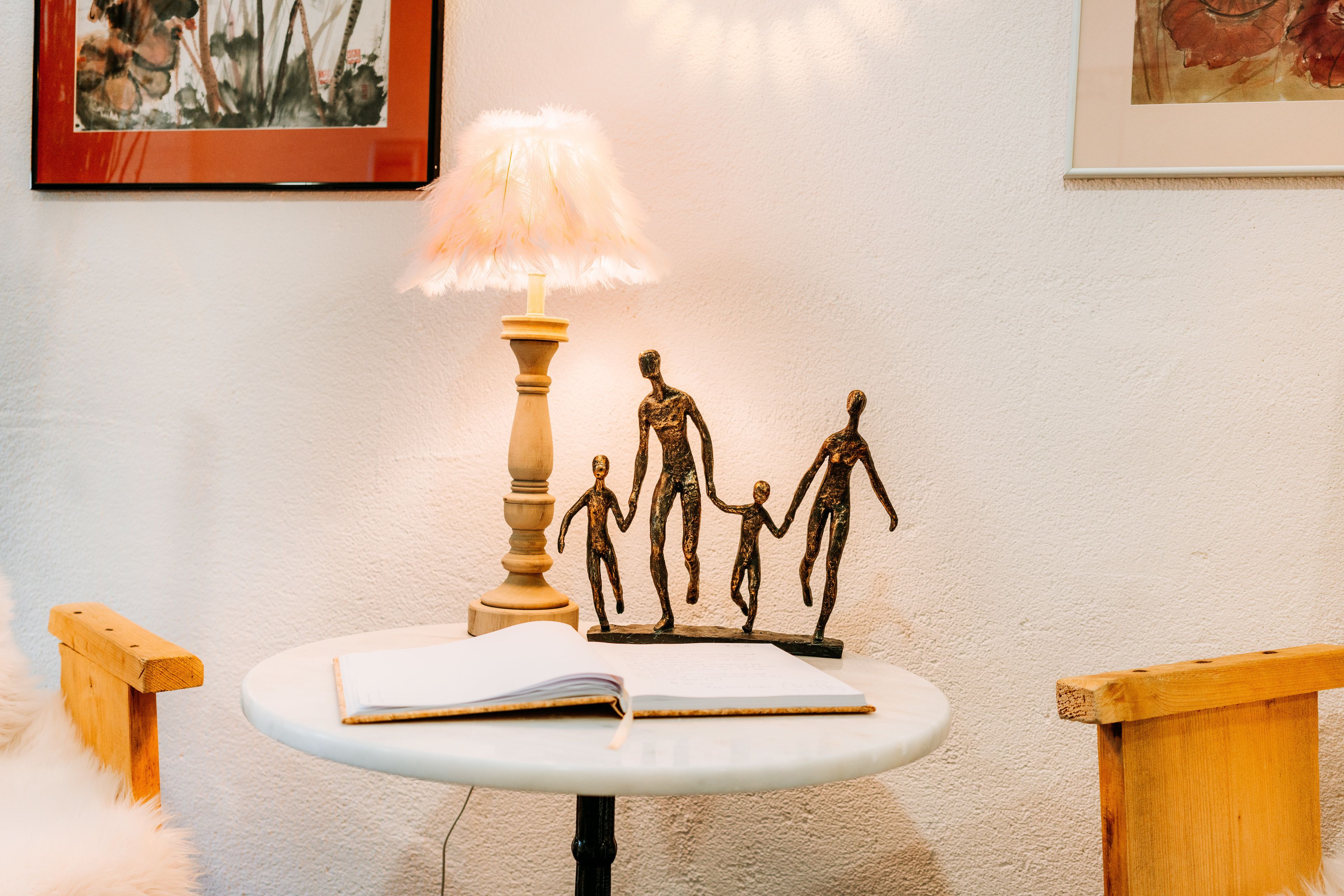 Ein Tisch mit einer Lampe, einer Familienfigur und einem offenen Buch.