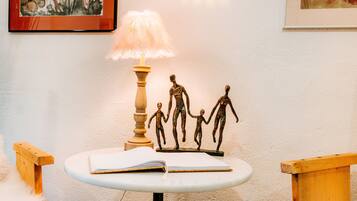 Ein Tisch mit einer Lampe, einer Familienfigur und einem offenen Buch.
