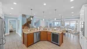 A spacious kitchen with wooden cabinets, granite countertops, and stainless steel appliances. - 🌊Less Stress: Oceanfront Home with Private Pool + Elevator🌊 (Kure Beach)