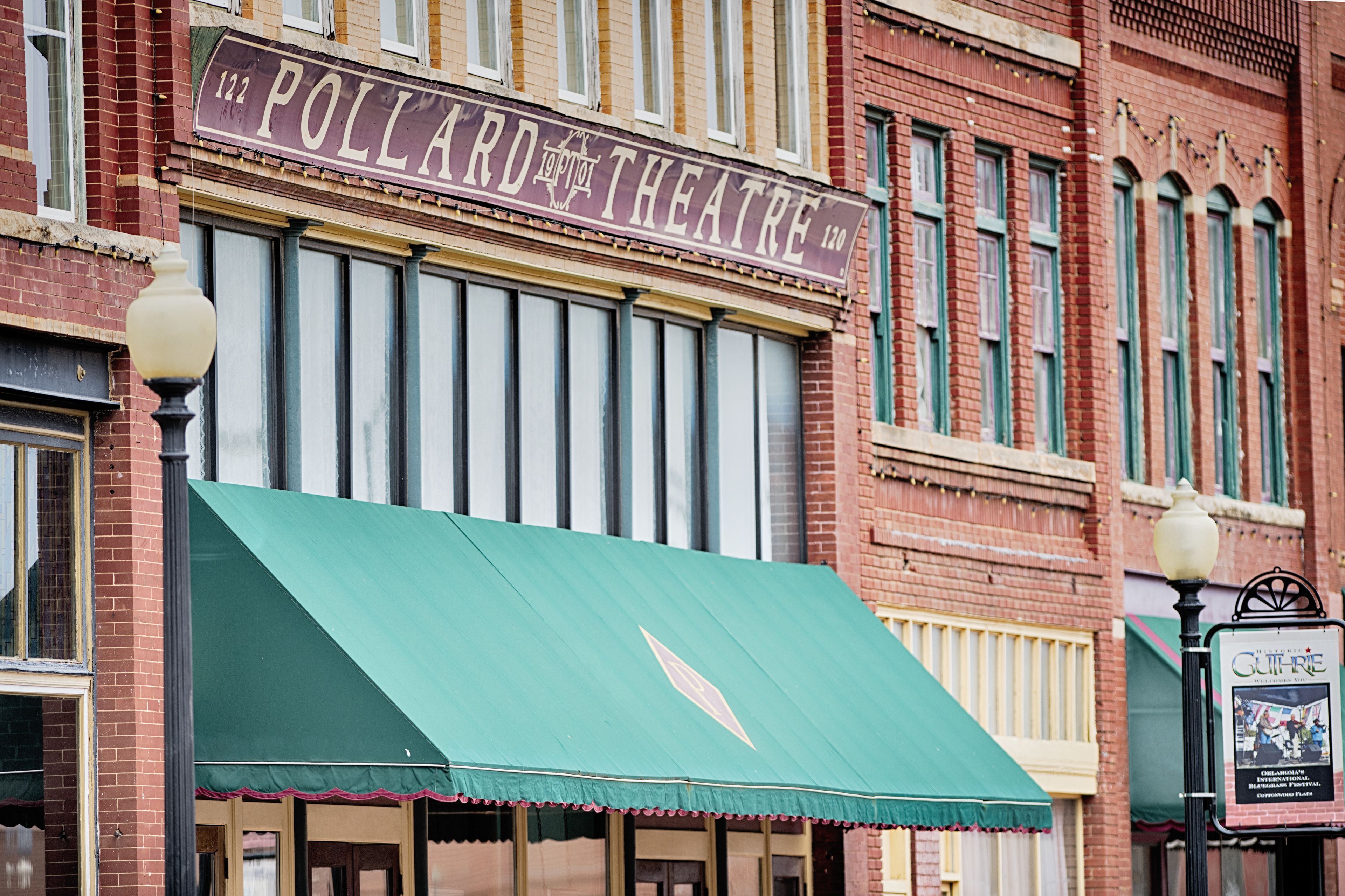 A building with a marquee sign reading "Pollard Theatre" and a green awning.