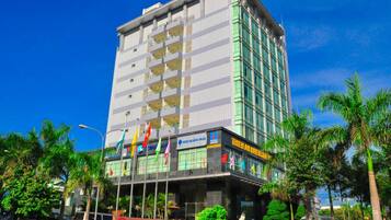 Stunning hotel building with a modern design, featuring a prominent entrance and lush surroundings.