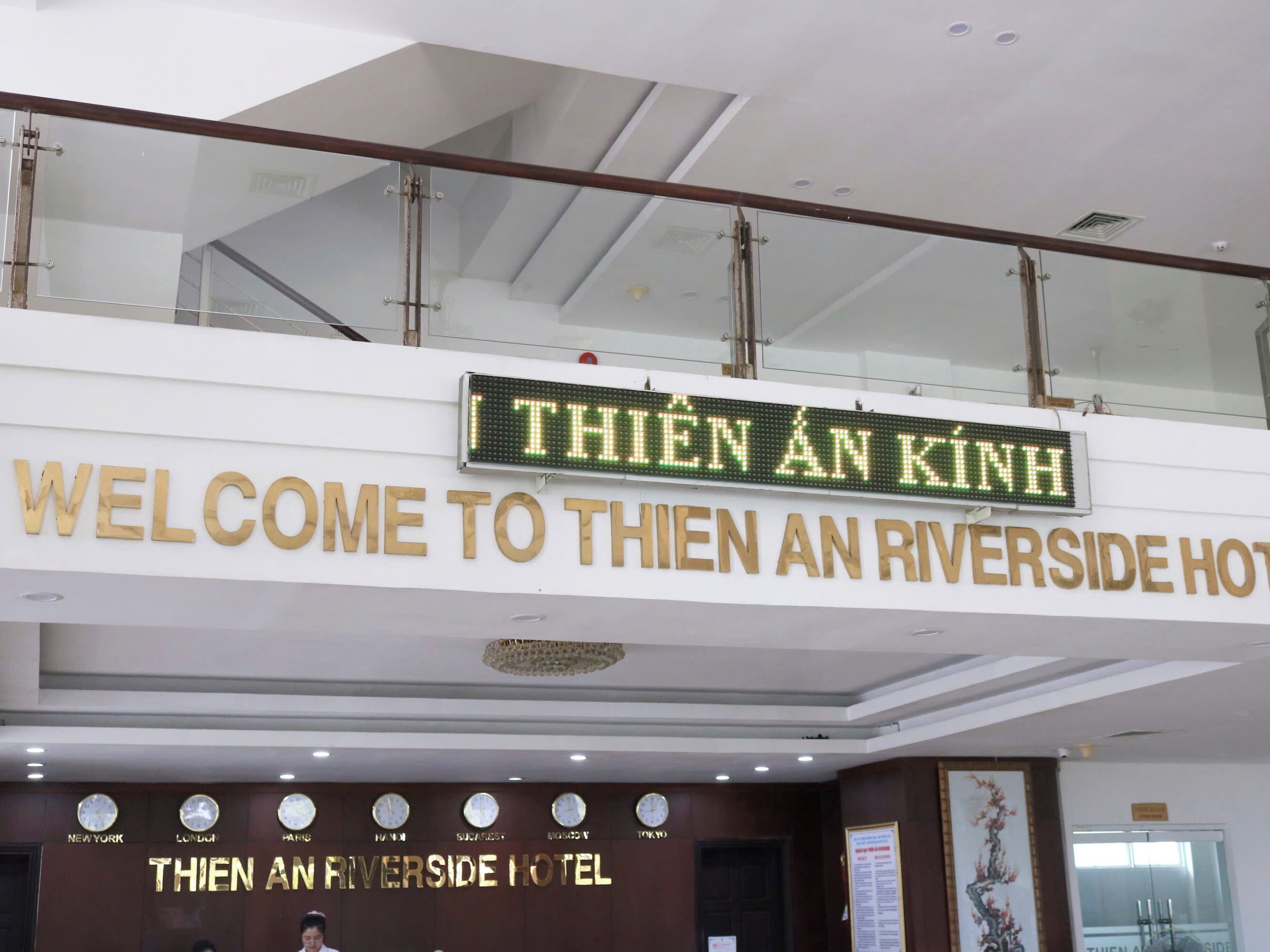 A hotel sign with "THIEN AN KINH" and "WELCOME TO THIEN AN RIVERSIDE HOTEL" in English and Vietnamese.