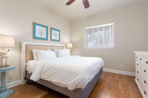A bedroom with a bed, two wall-mounted lamps, a window with blinds, and a dresser. - GREAT LOCATION ~ Luxury End-Unit Condo, Walk 2 Beach, Pool, Hot Tub,  FREE Activities!! (Miramar Beach)