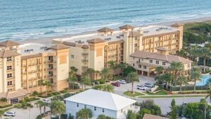 Un hôtel situé sur la côte, composé de plusieurs bâtiments, doté d’une piscine et offrant une vue sur la plage.