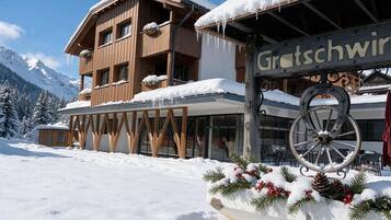 Un edificio in legno con un cartello che riporta 'Gratschwirt' e terreno innevato.