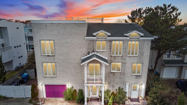 A two-story house with a brick facade, multiple windows, and a front porch. - 10Bd/10Ba Large Beach Home, Indoor Pool In Virginia Beach (Virginia beach)