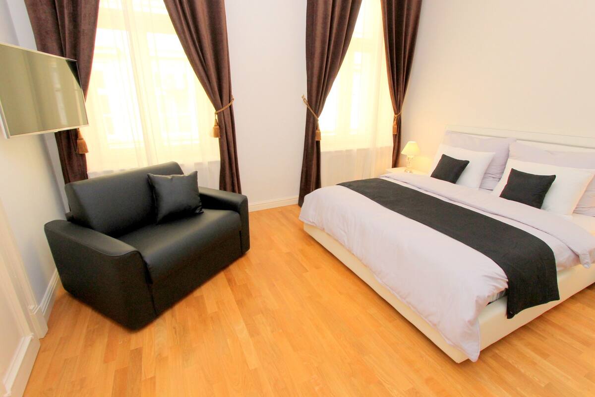 A room with a bed, a sofa, and a TV.