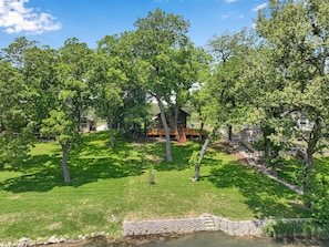 Escape to a serene retreat surrounded by mature trees and a tranquil water feature.