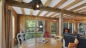 Un intérieur en bois avec une table ronde, des chaises et un canapé.
