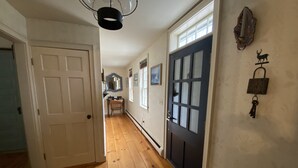 A hallway with wooden flooring, a white door, a dark door with frosted glass panels, and a wall-mounted key holder with a key. - Luxurious Farmhouse Style Home - Get away from it all in picturesque setting (Brownfield)