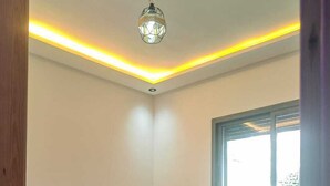 A bedroom with a bed, a nightstand, a wall-mounted light fixture, and a window. - Tidy and Calm appartment  equiped with WiFI  close to airport and ocean (Tanger)