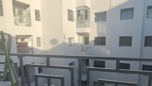 A multi-story residential building with balconies, a metal railing, and a clear sky. - Tidy and Calm appartment  equiped with WiFI  close to airport and ocean (Tanger)