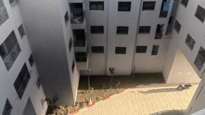 A multi-story residential building with balconies, windows, and a small garden area. - Tidy and Calm appartment  equiped with WiFI  close to airport and ocean (Tanger)