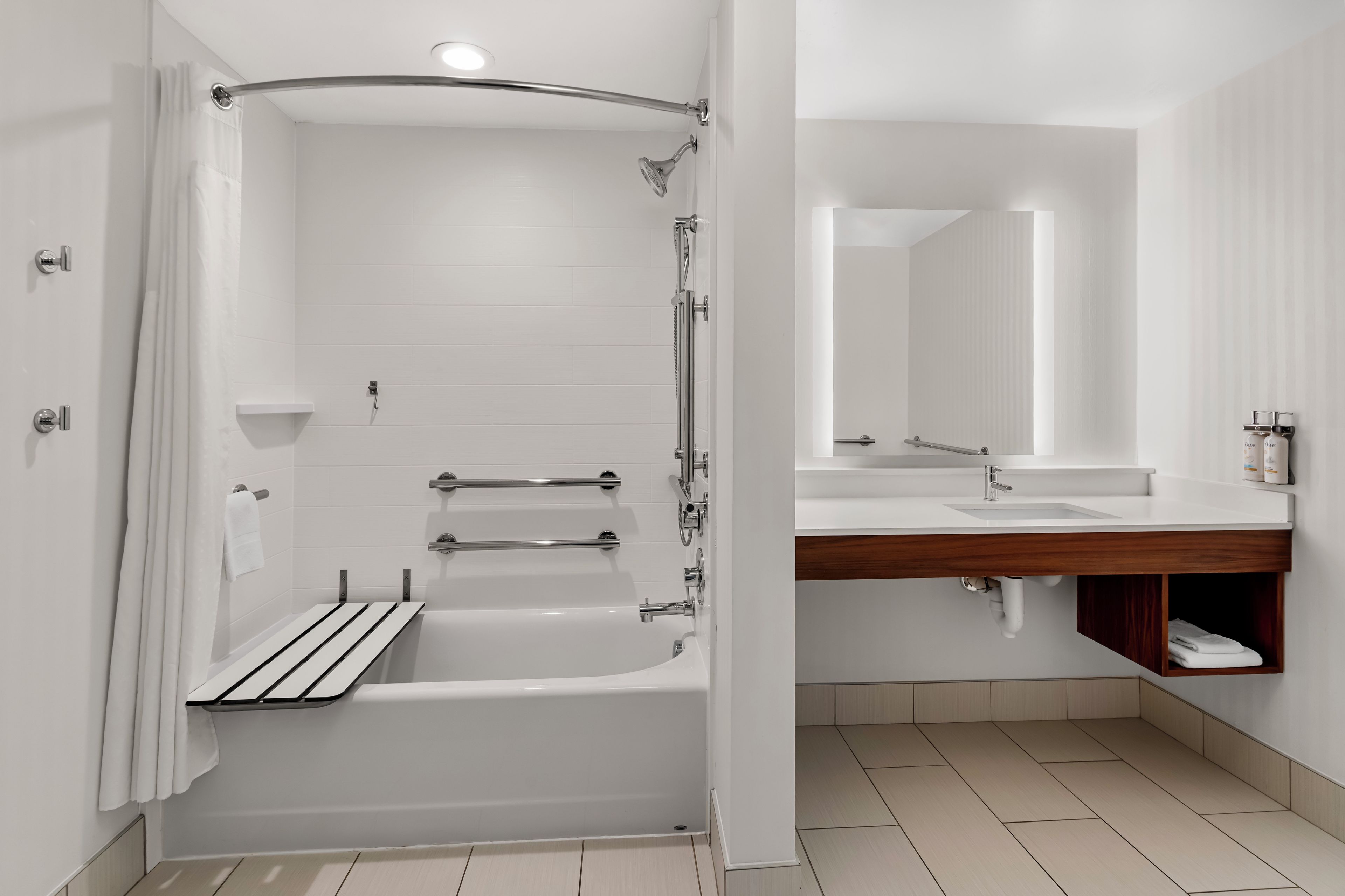 A modern bathroom with a bathtub, shower, and a vanity with a mirror.