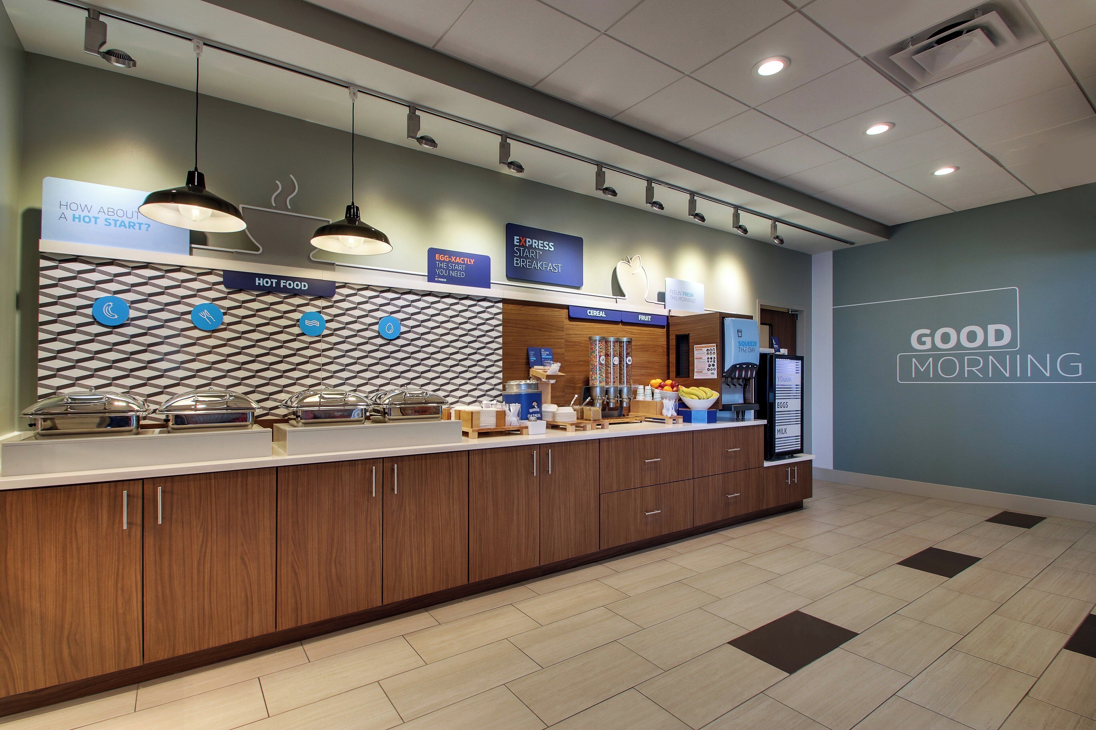 A breakfast area with a counter, food display, and a sign reading 'GOOD MORNING'.