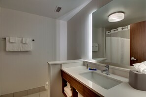 Un bagno moderno con uno specchio grande, un lavandino e un portasciugamani.