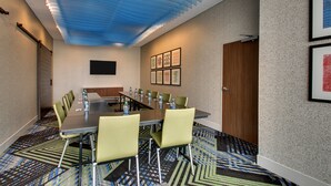 A conference room with a long table, green chairs, and a patterned carpet. - Holiday Inn Express & Suites Findlay North by IHG (Findlay)