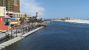 A waterfront hotel with a marina, a lighthouse, and a beach in the background. - Gipson Inn Motel (Fort Walton Beach)