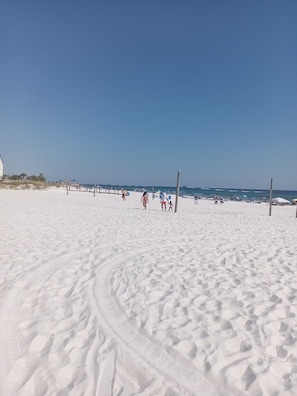 A sandy beach with footprints, a clear sky, and a few people in the distance. - Gipson Inn Motel (Fort Walton Beach)