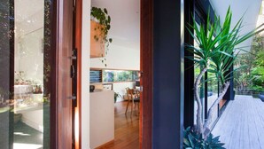 Une cuisine moderne avec des meubles en bois, un coin repas comprenant une table et des chaises, et une grande fenêtre donnant sur un jardin.
