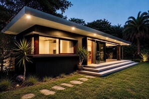 Una casa moderna con techo plano, ventanas amplias y una zona exterior cubierta.