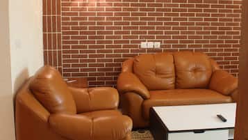Suite, 1 habitación | Sala de estar | Televisión de pantalla plana de 32 pulgadas con canales por cable