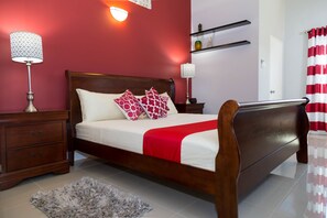 A bedroom with a wooden bed, two bedside tables, a nightstand, a red and white striped curtain, and a red wall. - Casa Princess Ocho Rios Vacation Villa (Ocho Rios)