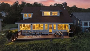 A two-story house with a covered patio, large windows, and a deck.