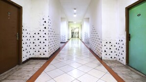 A hallway with patterned walls and doors, leading to a staircase. - Wisma Gading Indah (Jakarta)