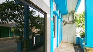 A covered entrance with blue pillars and a tiled floor, leading to a building with a visible door and a 'PULL' sign. - Wisma Gading Indah (Jakarta)