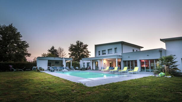 A modern house with a swimming pool, outdoor seating, and a well-maintained lawn. - Domaine Georges V (Saint-Junien)