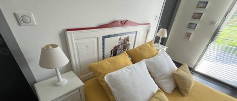 Una habitación de hotel con una cama, una mesita de noche blanca y una lámpara.