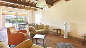 A spacious living area with a wooden ceiling, a sofa, a coffee table, and a dining table with chairs. - Wonderful private villa with A/C, WIFI, private pool, TV, veranda and panoramic view, close to L... (Colle Di Compito)