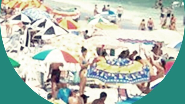 Uma praia movimentada, com pessoas e guarda-sóis coloridos.