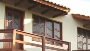 Um edifício de dois andares com varanda e telhado de cerâmica.
