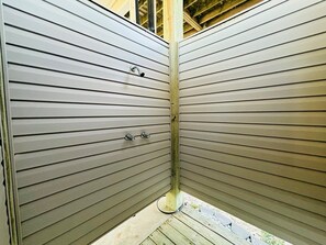 Esquina de una habitación con revestimiento horizontal y una viga de madera.