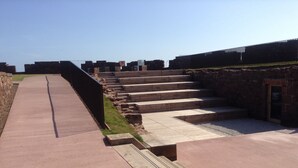 A pathway leading to a set of stone steps with a brick wall on one side and a fence on the other. - Unique 2 Bedroom Harbour Front Apartment. License No. EL00051F.     (Dunbar)