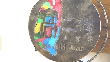 Un letrero circular con un diseño colorido y el texto "World Inn" en un soporte metálico.