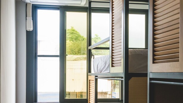 A room with bunk beds, a window with blinds, and a ceiling-mounted air conditioner. - World Inn - Hostel (Hualien City)