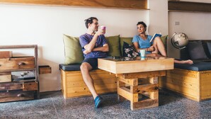 A cozy room with a wooden bench, a small wooden table, and a globe on a shelf. - World Inn - Hostel (Hualien City)