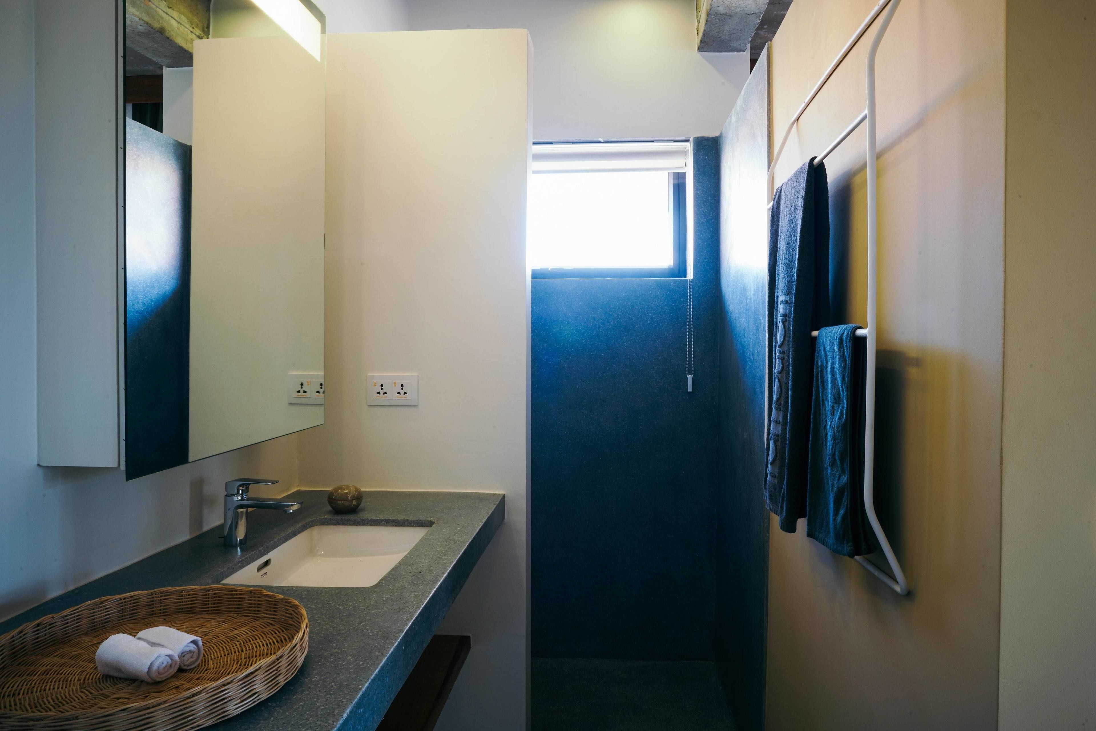A bathroom with a sink, mirror, and towel rack.