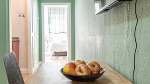 Un coin repas avec une table en bois et un saladier rempli de pommes.