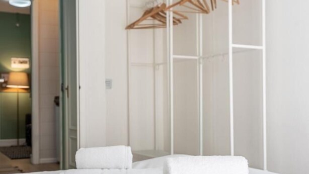 Une chambre d’hôtel avec un lit, une armoire et un miroir.
