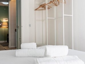 Una habitación de hotel con cama, armario y espejo.