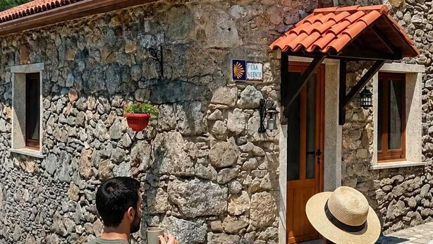 A stone building with a tiled roof, a chimney, and a small window with a sign. - Galician Stone Cottage for 2 people   (A Coruña)